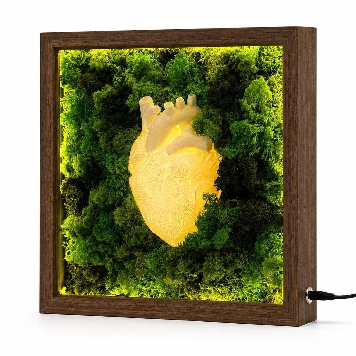 A lit frame of moss around a glowing heart form